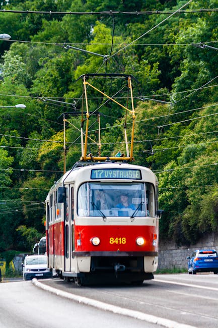 Vintage urban tram traveling through a lush green city corridor
