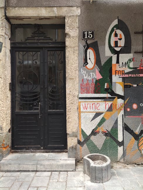 Modern artistic wine house entrance with graphic murals and black ornate door