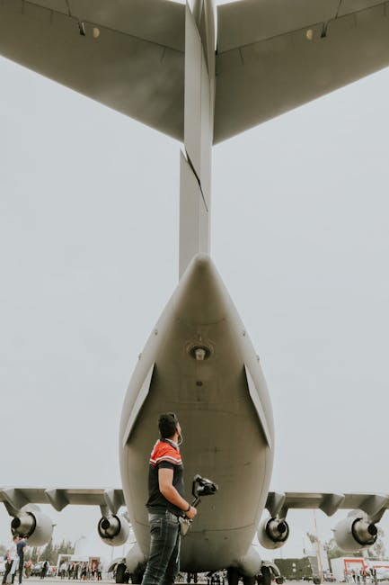 Rear view of a heavy transport aircraft with a professional operative in foreground