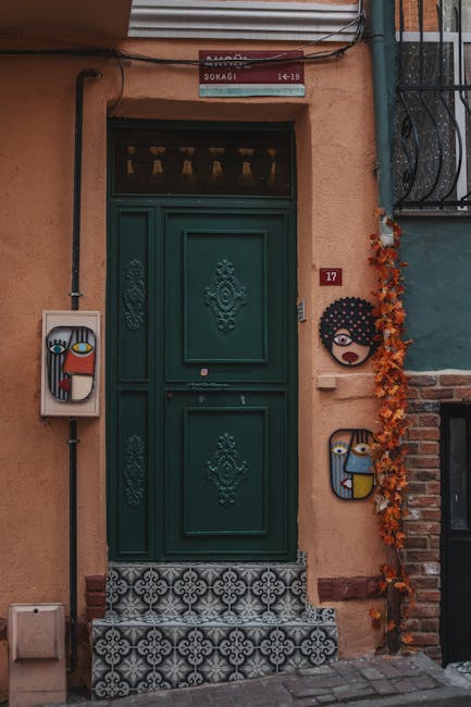 Decorative green door with artistic tiles and ceramic faces